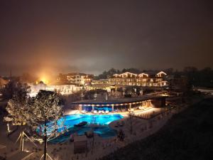 瓦兹Laschenskyhof Hotel & Spa的夜间带游泳池的度假村