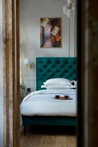 库尔迪加Modiste的一间卧室配有一张大床和绿色床头板