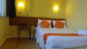 曼谷Asia Inn Bangkok 2022的酒店客房 - 带两张带橙色枕头的床