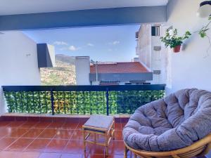 丰沙尔Casa Pico dos Barcelos by LovelyStay的一间带两把椅子的客厅和一个阳台
