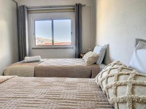 丰沙尔Casa Pico dos Barcelos by LovelyStay的带窗户的客房内的两张床