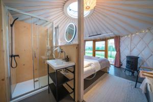 GajowkaIzera Glamping Adults - Luksusowe jurty&spa (adults only)的卧室配有床和盥洗盆