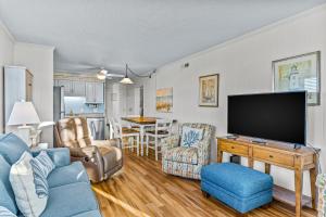 海洋岛海滩Ocean Isle Retreat的客厅配有蓝色的沙发和电视