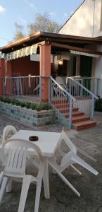 帕利努罗Casa Vacanze Mimose的两把白色椅子和一张桌子,位于房子前面