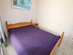 勒格罗-迪鲁瓦Appartement Le Grau-du-Roi, 2 pièces, 4 personnes - FR-1-307-11的卧室内的一张带紫色棉被的床
