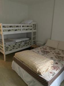 桑托斯Apartamento frente Mar Santos的一间卧室配有一张床和两张双层床。