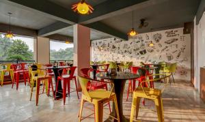 班加罗尔Treebo Trend Three Street Inn的餐厅设有红色和黄色的椅子和桌子