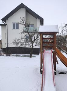 波普拉德Ubytovanie pre Vás的房屋前的雪覆盖游乐场