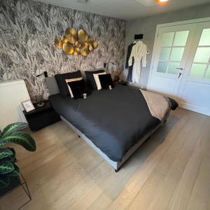 拉纳肯Bed & Bokes aan de Maaskant的一间卧室配有一张黑色大床和墙壁