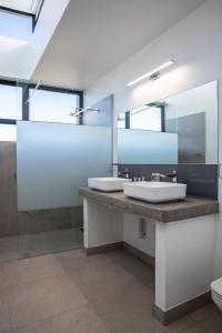 普利登堡湾Hilltop Bayview Luxury Apartments的一间带两个盥洗盆和大镜子的浴室