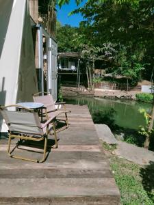 Ban Khanong Phra Klang (1)Brook Cottage的木甲板上的两张躺椅和一张桌子