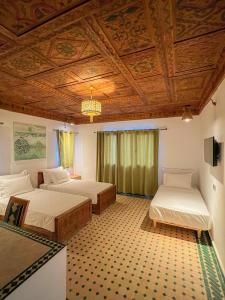 梅尔祖卡Desert Villa Boutique Hotel Merzouga的一间卧室设有两张床和木制天花板