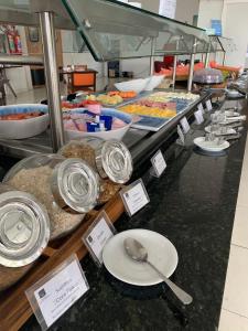 圣若昂迪梅里蒂Nobile Inn Dutra Rio De Janeiro的柜台上的自助菜谱,包括菜肴和汤匙