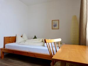 塔弗伊拜耳格弗朗森雪和酒店的一张位于带桌子和椅子的房间内的床铺