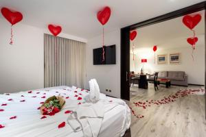 波哥大Hotel Madisson Inn Luxury By GEH Suites的一间卧室,配有一张红色的床