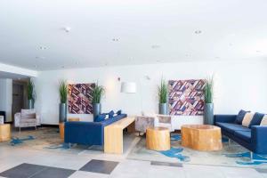 乔治王子城乔治王子城桑德曼签名酒店的大堂设有蓝色的沙发、桌子和植物