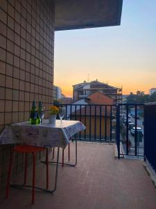 科莱尼奥APPARTAMENTO COMFORT e SERVIZI - Casa Gramsci的阳台上配有一张桌子、两瓶和两把椅子
