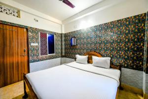 普里Goroomgo Ray Home Stay Swargadwar Puri的卧室配有白色的床