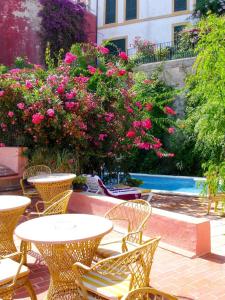 伊维萨镇Navila Palmera的户外庭院配有桌椅和粉红色的鲜花
