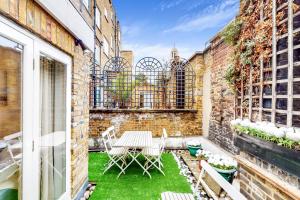 伦敦Park Lane Apartments Marble Arch的砖砌建筑中带桌椅的庭院