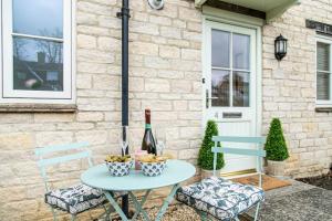 巴拉顿Oxfordshire Living - The Sunderland Apartment - Bladon的一张桌子、一瓶葡萄酒和两把椅子