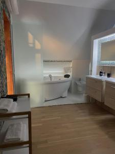 利耶帕亚Boutique Guest House的白色的浴室设有浴缸和卫生间。