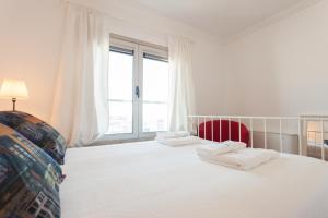 里斯本FLH Expo Cozy Apartment的卧室配有一张白色大床和红色椅子