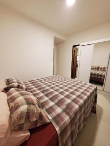 卡马萨里Village de Praia Duplex Arembepe的一间卧室配有一张带铺着平底毯的床