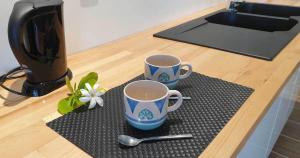 TiputaMoana Breeze Eco Lodge的厨房柜台的垫子上放两个咖啡杯