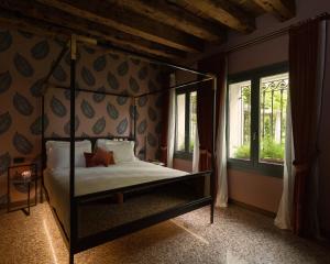 威尼斯Madama Garden Retreat的一间卧室设有四柱床和窗户。