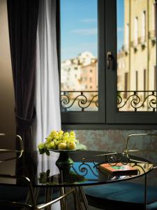 威尼斯Madama Garden Retreat的窗前带葡萄板的桌子