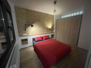 亚历山德鲁波利斯Central cozy apartment with garden的一间卧室配有一张带红色床单的床和电视。