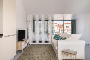 里斯本Succeed Campo Pequeno Apartments的白色的客厅配有白色的沙发和电视