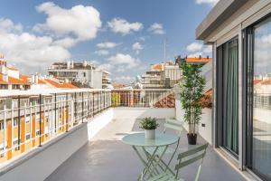 里斯本Succeed Campo Pequeno Apartments的设有一个配有桌椅并享有美景的阳台。