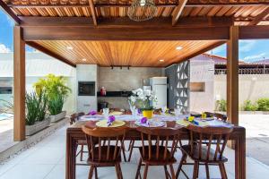 尼西亚弗洛雷斯塔Incrível casa na Praia de Camurupim por Carpediem的开放式厨房以及带木桌和椅子的用餐室。