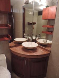 利马旅行者公寓的一间带两个盥洗盆和大镜子的浴室