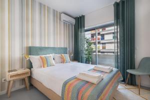 里斯本Succeed Campo Pequeno Apartments的一间卧室设有一张大床和一个窗户。