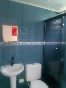 博拉塞亚Pousada Chalé Boracéia的蓝色的浴室设有卫生间和水槽