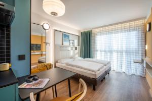 汉堡Aparthotel Adagio access Hamburg的一间卧室配有一张床和一张书桌