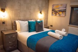 伯明翰Silver Forge - Luxury High End Two Bedroom - En Suite - City Centre的一间卧室配有一张大床,提供蓝色的床单和枕头