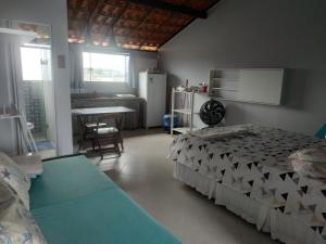 伊列乌斯VENTO E SAL - Cobertura MAR的一间卧室配有一张床,厨房配有桌子