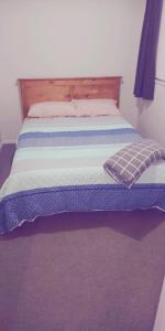 罗托鲁瓦Modest comfortable relaxed home away from home的床上有蓝色和白色的毯子