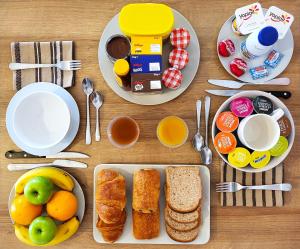 勒唐蓬Tiny House Chaleureuse au Style Contemporain Minimaliste的餐桌,带早餐食品和餐具盘