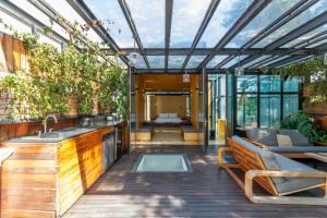 墨西哥城Casa Wynwood Roma Norte的室外厨房和带玻璃屋顶的客厅