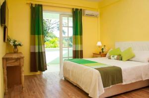 罗索钻石怡景别墅酒店的一间卧室设有一张带绿色和黄色墙壁的床。