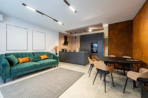 罗兹Luxury Copper Apartment II的客厅配有绿色沙发和桌子