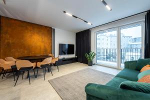 罗兹Luxury Copper Apartment II的客厅配有绿色沙发和桌子