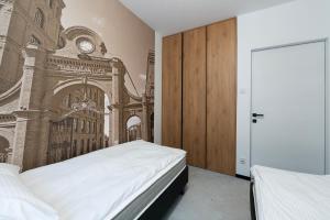 罗兹Luxury Copper Apartment II的一间卧室设有两张床,墙上挂着一幅画