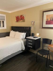 弗林弗隆Oreland Motel的一间卧室配有一张床、一张桌子和一把椅子