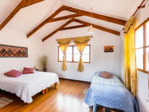 普特雷La Chakana Lodge的客房内设有两张床,铺有木地板,设有窗户。